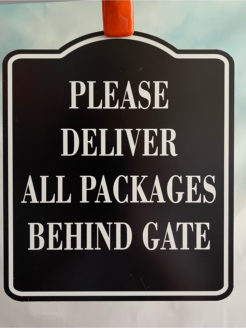Black and White Packages Behind Gate Sign